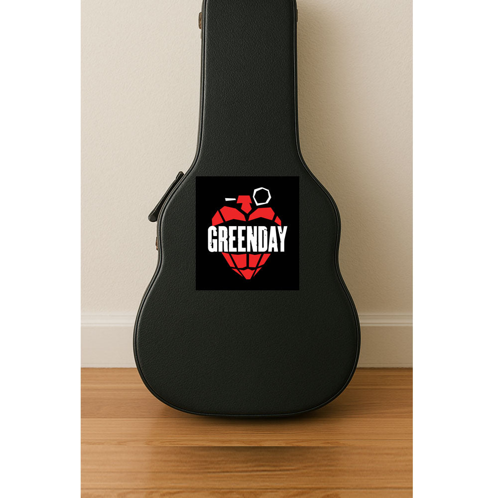 Black guitar case with Greenday logo on a wooden floor against a beige wall.
