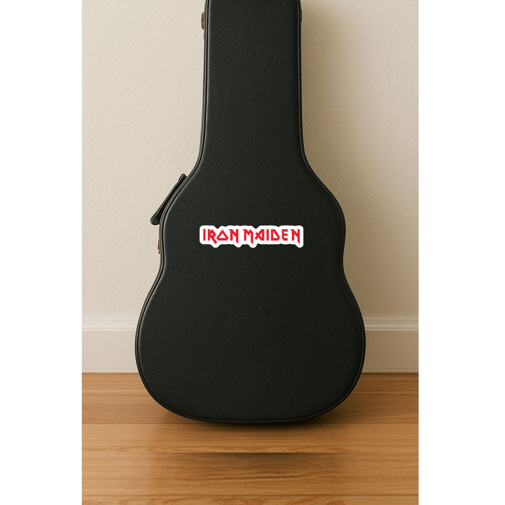 Black guitar case with Iron Maiden logo on a wooden floor against a beige wall.